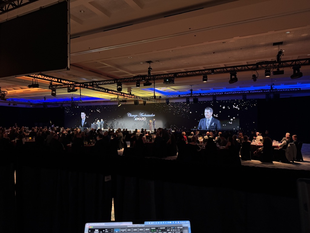 Quadra QCC conference general session in Vancouver with presenter on screen